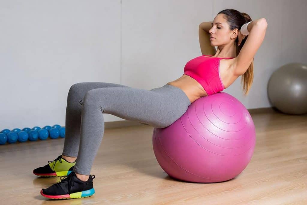 woman on stability ball doing sit-ups