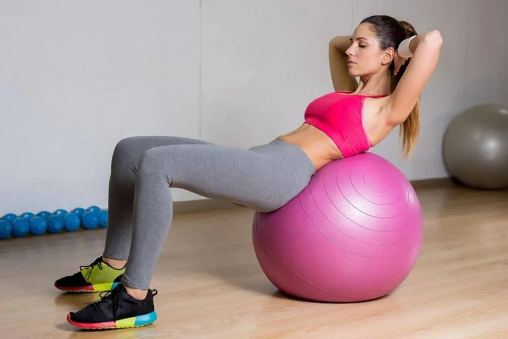 woman on stability ball doing sit-ups