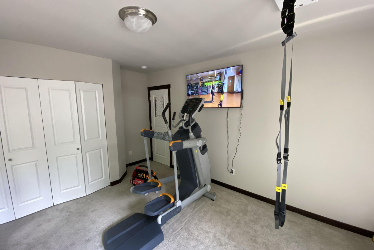 TRX suspension training system hanging in home gym room