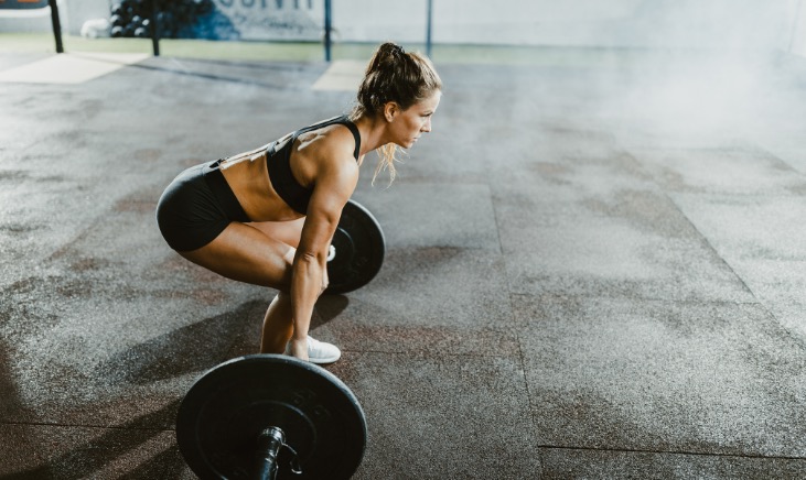 Woman working out in a gym performing a Deadlift