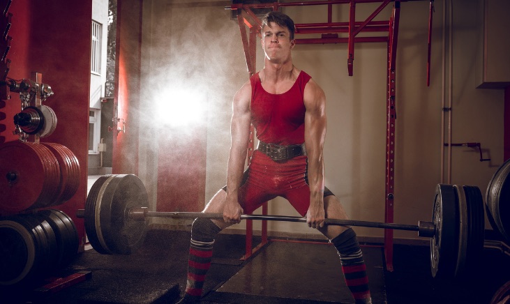 Man in his home gym performing a deadlift
